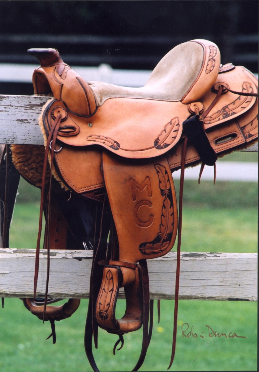 Western saddle on fence